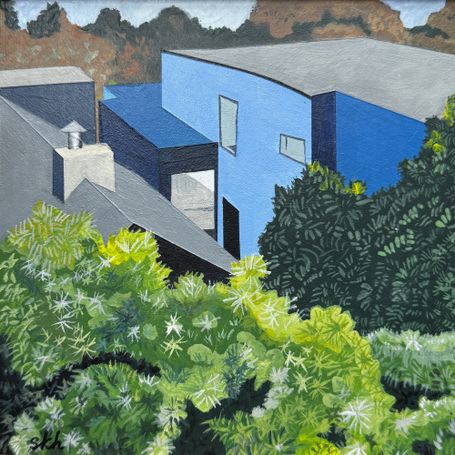 Back of blue house with foliage in foreground