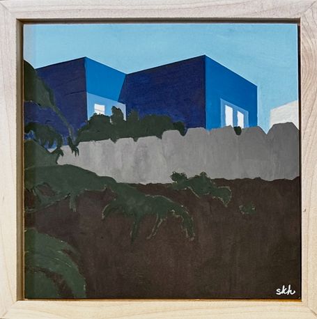 Small view over the back of a fence to blue home beyond