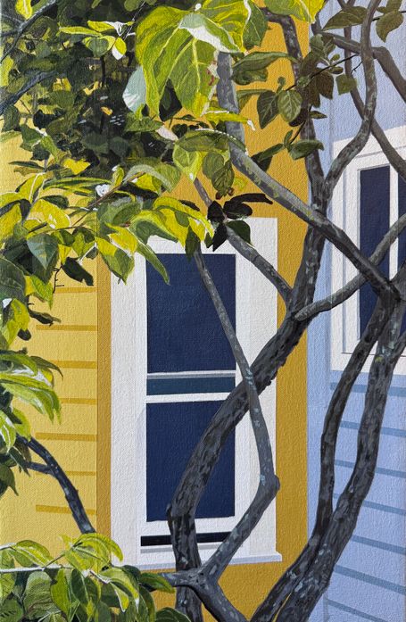 Yellow house exterior with window behind tree